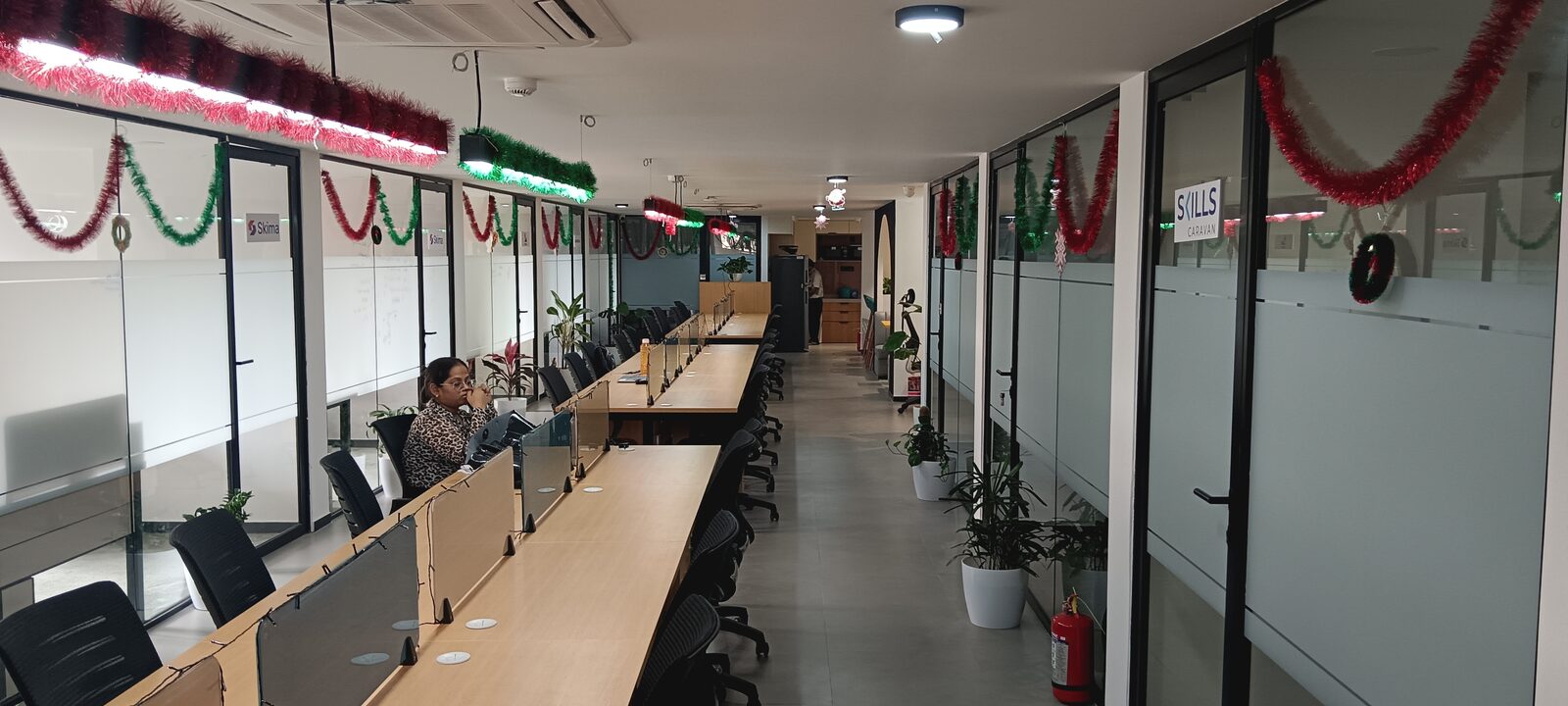 An open coworking floor with shared desks and glass meeting rooms